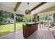 Screened-in porch with an outdoor bar area, wood beams, and backyard views at 12636 Old Creedmoor Rd, Raleigh, NC 27613