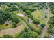 Aerial view showcases the property, horse arena, pond, pastures, and tree lined surroundings at 12823 Summerwind Trl, Rougemont, NC 27572
