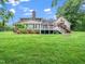 Sprawling backyard featuring a multi-level deck, lush greenery, and mature trees at 12823 Summerwind Trl, Rougemont, NC 27572