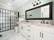 Bathroom boasts double vanities with granite countertops, white cabinets, and a modern glass shower at 12823 Summerwind Trl, Rougemont, NC 27572
