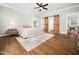 Bedroom featuring hardwood floors, sliding barn doors, and plenty of natural light at 12823 Summerwind Trl, Rougemont, NC 27572