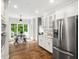 Eat-in kitchen features white cabinetry, stainless steel appliances, and a view of the deck at 12823 Summerwind Trl, Rougemont, NC 27572