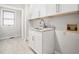 The laundry room features white cabinets, granite countertop, tile flooring, and a window at 12823 Summerwind Trl, Rougemont, NC 27572