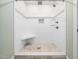 Step into this tiled shower featuring a built-in bench, shower niche, and decorative mosaic floor at 12823 Summerwind Trl, Rougemont, NC 27572