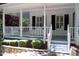 Inviting covered front porch with white railing, black shutters, and a charming entryway at 1300 Keynes Ct, Raleigh, NC 27615