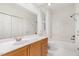 Bathroom with a vanity, large mirror, tub, shower, and shuttered window providing natural light at 1310 Durlain Dr # 107, Raleigh, NC 27614