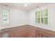 Spacious bedroom with hardwood floors, white trim, and natural light from shuttered windows at 1310 Durlain Dr # 107, Raleigh, NC 27614