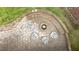 Aerial view of a backyard firepit with stone seating creating a cozy outdoor retreat at 1332 Kinsdale Dr, Raleigh, NC 27615