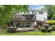 Expansive backyard with large deck, stone patio, and lush landscaping, perfect for outdoor living and entertaining at 1332 Kinsdale Dr, Raleigh, NC 27615