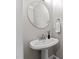 Bathroom featuring a pedestal sink and round mirror at 1332 Kinsdale Dr, Raleigh, NC 27615