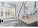 Cozy bathroom featuring a vanity with solid surface countertops, under mount sink, and arched window over the commode at 1332 Kinsdale Dr, Raleigh, NC 27615