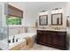 Bathroom featuring a soaking tub, dual vanity and a tiled shower with a glass door at 1332 Kinsdale Dr, Raleigh, NC 27615