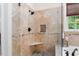 Elegant bathroom featuring a tiled shower with a glass door and a built-in seat at 1332 Kinsdale Dr, Raleigh, NC 27615