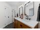 Bathroom with double vanity, dark fixtures, wood cabinets, and two mirrors at 1332 Kinsdale Dr, Raleigh, NC 27615