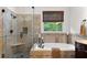 Elegant bathroom featuring a soaking tub and a tiled shower with a glass door at 1332 Kinsdale Dr, Raleigh, NC 27615