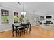 Dining area with black table and chairs features natural light and hardwood floors at 1332 Kinsdale Dr, Raleigh, NC 27615