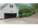 A very long driveway with a black garage door and lush landscaping at 1332 Kinsdale Dr, Raleigh, NC 27615