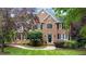 Stately brick home featuring a well-manicured lawn and mature landscaping at 1332 Kinsdale Dr, Raleigh, NC 27615