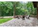 Beautiful backyard fire pit with stone seating, surrounded by lush trees, creating a cozy outdoor retreat at 1332 Kinsdale Dr, Raleigh, NC 27615