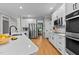 Bright kitchen features stainless appliances, wooden floors, and white cabinetry at 1332 Kinsdale Dr, Raleigh, NC 27615