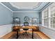 Home office with blue walls, white trim, wood floors, and a modern desk setup at 1332 Kinsdale Dr, Raleigh, NC 27615