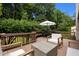Back deck featuring a seating area, umbrella-covered dining table, and views of a lush green yard at 1706 Rangecrest Rd, Raleigh, NC 27612