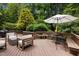 Back deck featuring a grill, seating area, and an umbrella-covered dining table at 1706 Rangecrest Rd, Raleigh, NC 27612
