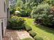 Beautiful backyard with a stone patio, wooden deck and walkway surrounded by lush landscaping and mature trees at 1706 Rangecrest Rd, Raleigh, NC 27612