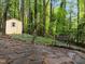 Outdoor storage shed with a quaint design, nestled among mature trees and stone pathway at 1706 Rangecrest Rd, Raleigh, NC 27612