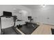 Basement gym featuring a treadmill, weight bench, mirrored wall, and lots of storage at 1706 Rangecrest Rd, Raleigh, NC 27612