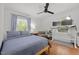 Bright bedroom features hardwood floors, a ceiling fan, and a dedicated desk and monitor setup at 1706 Rangecrest Rd, Raleigh, NC 27612
