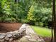 Stone pathway winds through manicured garden beds with diverse plantings and rock borders at 1706 Rangecrest Rd, Raleigh, NC 27612