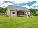 Spacious backyard with lush green grass, wooden deck, and play set for Gathering entertainment and relaxation at 1779 Walter Grissom Rd, Kittrell, NC 27544