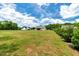 Expansive lawn featuring lush greenery, mature trees, and scenic views of surrounding homes and landscape at 1779 Walter Grissom Rd, Kittrell, NC 27544