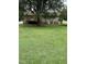 A large grassy backyard featuring an exterior deck and tree coverage at 1942 Brier Ln, Graham, NC 27253