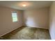 Simple bedroom with neutral walls, classic carpet, and a window, offers a calm and adaptable living space at 1942 Brier Ln, Graham, NC 27253