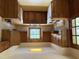 Retro kitchen featuring wood cabinets, window with a view, and white appliances, blending vintage charm at 1942 Brier Ln, Graham, NC 27253