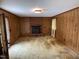A warm living room with wood paneling and a brick fireplace at 1942 Brier Ln, Graham, NC 27253