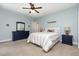 Cozy bedroom features blue walls, a ceiling fan, a comfortable bed, and matching dressers at 20 Wood Ibis Way, Louisburg, NC 27549
