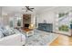Cozy living room with stone fireplace, hardwood floors, and large windows at 20 Wood Ibis Way, Louisburg, NC 27549