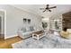 Open living room featuring hardwood floors, a ceiling fan, and lots of natural light at 20 Wood Ibis Way, Louisburg, NC 27549