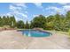 Backyard pool surrounded by mature landscaping and chairs for relaxing at 20 Wood Ibis Way, Louisburg, NC 27549