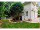Landscaped backyard featuring a walkway, mature trees, and access to the garage at 200 Cobblepoint Way, Holly Springs, NC 27540