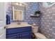 Charming powder room with blue patterned wallpaper and a vanity with a blue cabinet at 200 Cobblepoint Way, Holly Springs, NC 27540