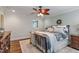 Comfortable bedroom featuring a ceiling fan, a bed with decorative pillows, and wood flooring at 200 Cobblepoint Way, Holly Springs, NC 27540