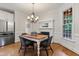 Cozy dining area with a fireplace, chandelier, and views of the backyard at 200 Cobblepoint Way, Holly Springs, NC 27540