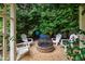 Backyard gravel area with stone fire pit and white Adirondack chairs at 200 Cobblepoint Way, Holly Springs, NC 27540