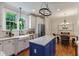 Bright kitchen with stainless steel appliances, blue island with granite countertops, and breakfast nook at 200 Cobblepoint Way, Holly Springs, NC 27540