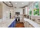 Well-lit kitchen featuring white cabinets, granite countertops, and a farmhouse sink at 200 Cobblepoint Way, Holly Springs, NC 27540