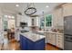 Stylish kitchen with custom cabinetry, granite countertops, stainless steel appliances, and hardwood floors at 200 Cobblepoint Way, Holly Springs, NC 27540